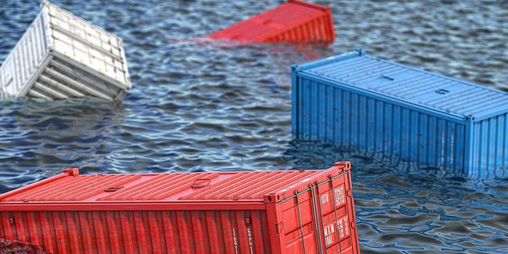Vier schwimmende Container im Meer.