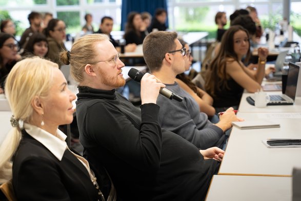 Gruppe von internationalen Studierenden und Lehrenden in einer Diskussion