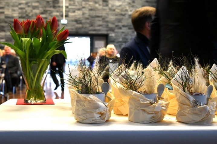im Vordergrund stehen Geschenke und eine Vase mit roten Tulpen auf einem Tisch