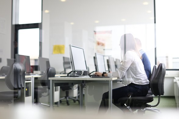Zwei Studierende sitzen an Computern in einem EDV-Raum.