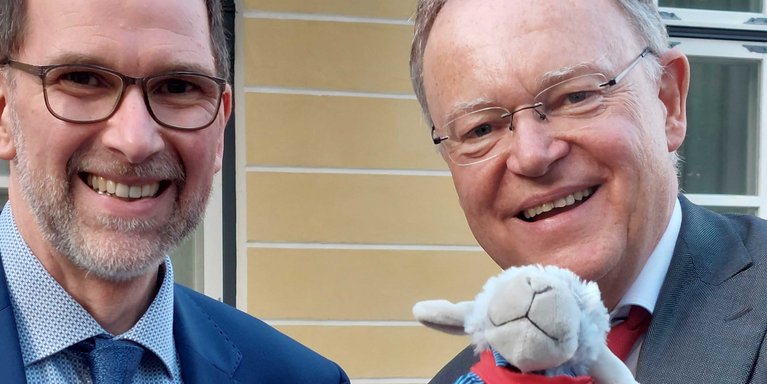 Ministerpräsident Weil (rechts) freut sich über „Wolle“. Überreicht wurde das Maskottchen des International Office der Jade Hochschule von Vizepräsident Saß. (Foto: Jade HS)