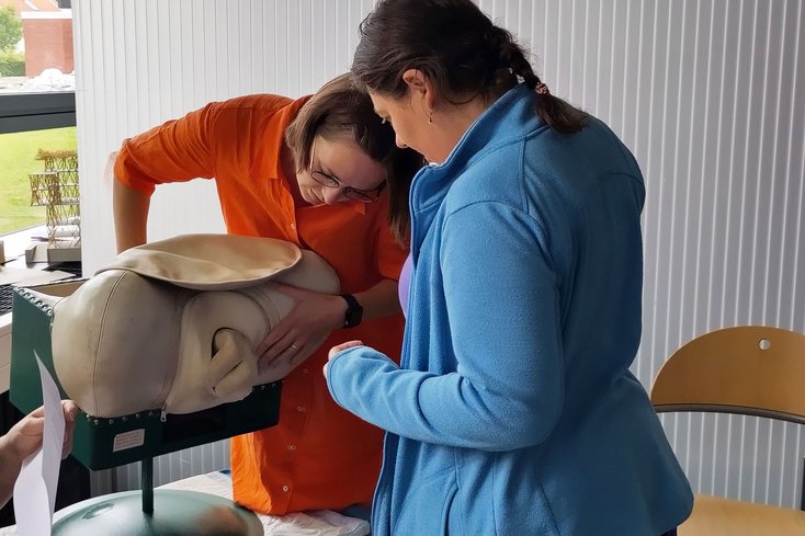 Simulierte Geburt aus Beckenendlage am sogenannten Phantom. Irene Schürholz, LfbA im Studiengang mit interessierter Schauspielerin während einer Prüfungspause (Foto: Jade HS/Oda von Rahden)