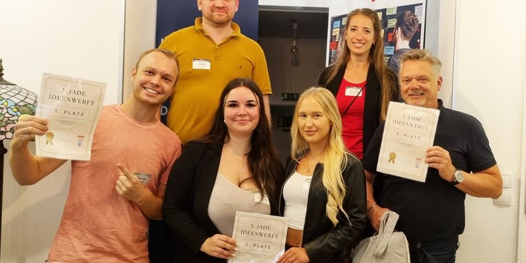 Zu den glücklichen Gewinner_innen der dritten Jade Ideenwerft zählten (unten v.l.n.r.) Florian mit seinem nachhaltigen Start-Up "ancol", Romina und Kira mit ihrer Tourismus-App "Roki Travel" und Frank mit seiner Karriereberatung "Coachinglabor". Die Preise überreichten Julian Fuchs (Baerenstark Media) und Annika Schöbel (Jade HS). (Foto: Daniela Wrage/Jade HS)