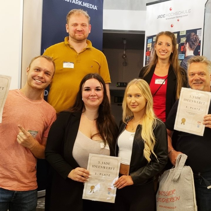 Zu den glücklichen Gewinner_innen der dritten Jade Ideenwerft zählten (unten v.l.n.r.) Florian mit seinem nachhaltigen Start-Up "ancol", Romina und Kira mit ihrer Tourismus-App "Roki Travel" und Frank mit seiner Karriereberatung "Coachinglabor". Die Preise überreichten Julian Fuchs (Baerenstark Media) und Annika Schöbel (Jade HS). (Foto: Daniela Wrage/Jade HS)