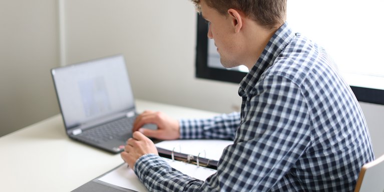 Studierender sitzt vor seinem Laptop