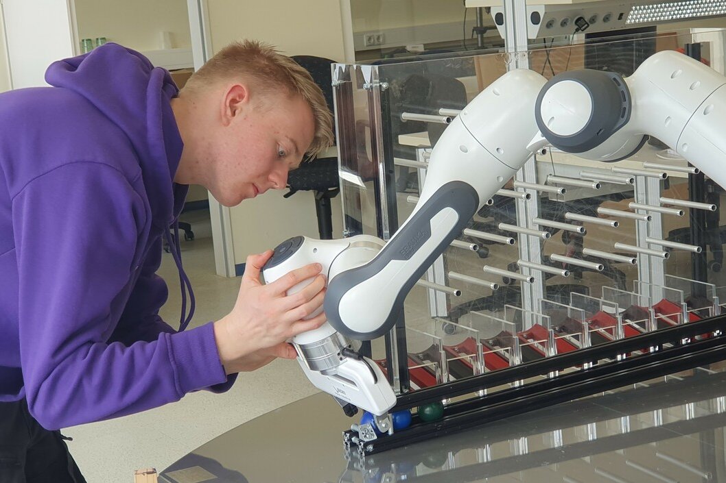 Foto: Workshopteilnehmer mit Roboter