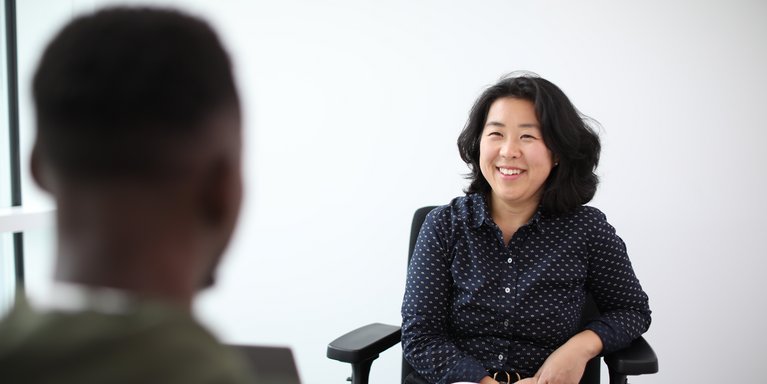 Zwei Personen unterhalten sich am Schreibtisch.