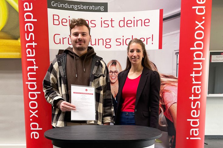 Sebastian Feldmann studiert Elektrotechnik dual im Fachbereich Ingenieurwissenschaften und absolvierte innerhalb von zwei Semestern das „Zertifikat Entrepreneurship“. Zum Semesterstart überreicht Annika Schöbel, Vorsitzende des Instituts für Unternehmensgründung und Innovation, die Urkunde. (Foto: Jade HS/Robin Schneider)