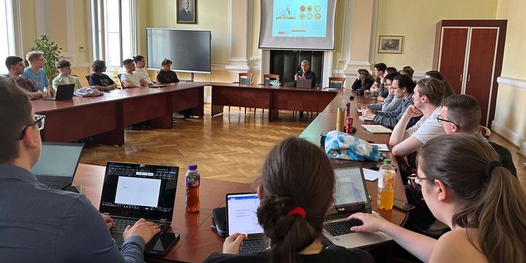 Maria Dudas (2. v. r.) aus dem International Office gab den Teilnehmenden auf dem Gellertberg spontan eine Freilicht-Vorlesung über die Stadtgeschichte Budapests. (Foto: Jade HS/Paul Beckmann)