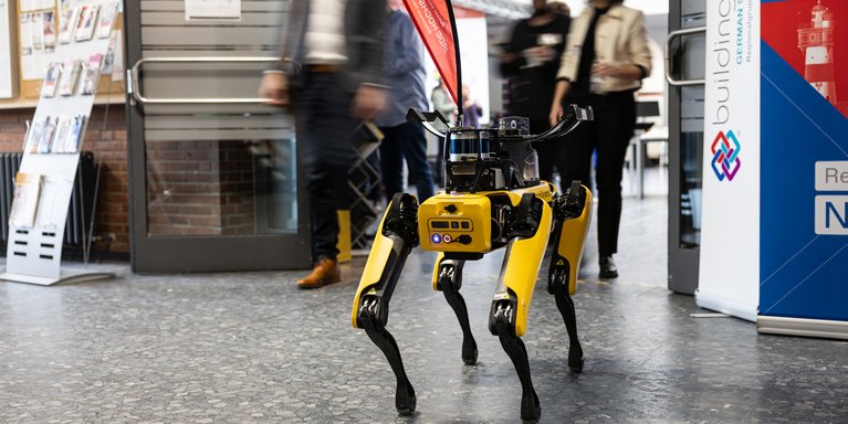 Roboterhund geht durch Veranstaltung.