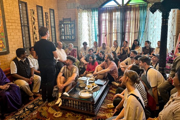 Studierende in Indien in einem Raum auf dem Boden sitzen im Gespräch