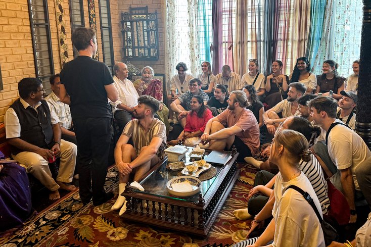 Studierende in Indien in einem Raum auf dem Boden sitzen im Gespräch