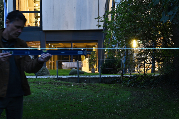 Für eine künstlerische Intervention in Oldenburg installiert Franz John einen Lichtdraht am Staatstheater mithilfe einer Wasserwaage. Foto: Alfred Janßen