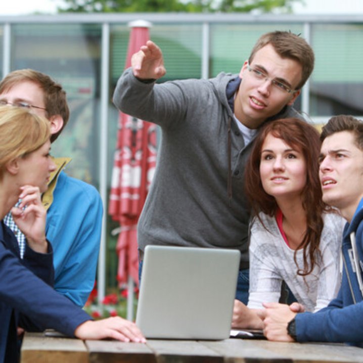 Personen sitzen um einen Tisch