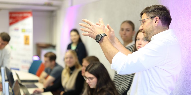 Dozent erklärt Studierenden etwas.