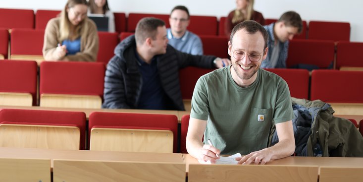 Studierende sitzen in einem Vorlesungsraum.