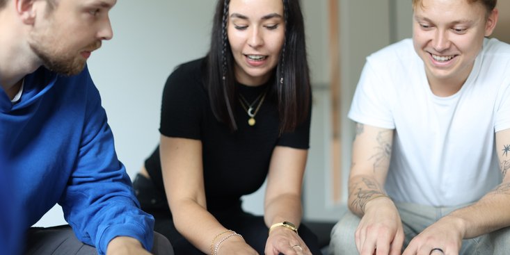 Eine Studentin erklärt ihren Kommilitonen etwas.