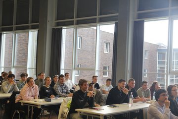 Erstsemesterstudierende verfolgen einem Vortrag in der Aula.