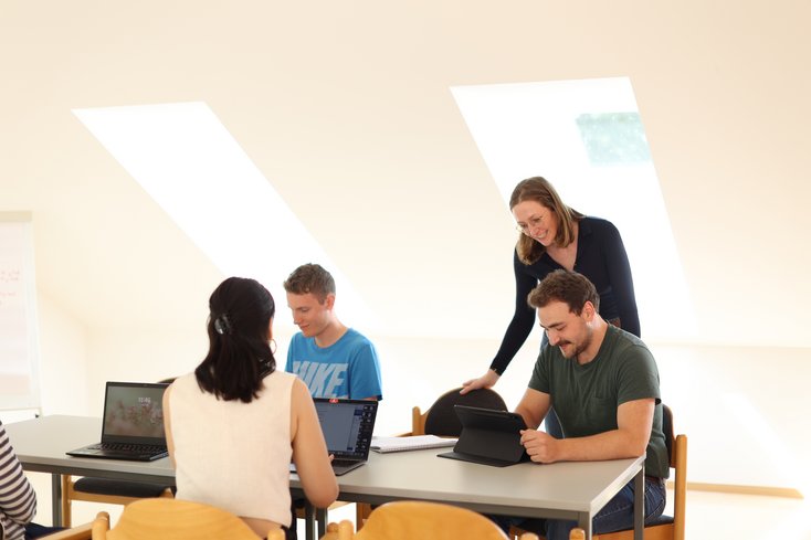 Dozentin führt Übung in kleiner Studierendengruppe durch.