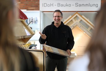 Dozent erklärt Studierenden etwas am Handmuster.