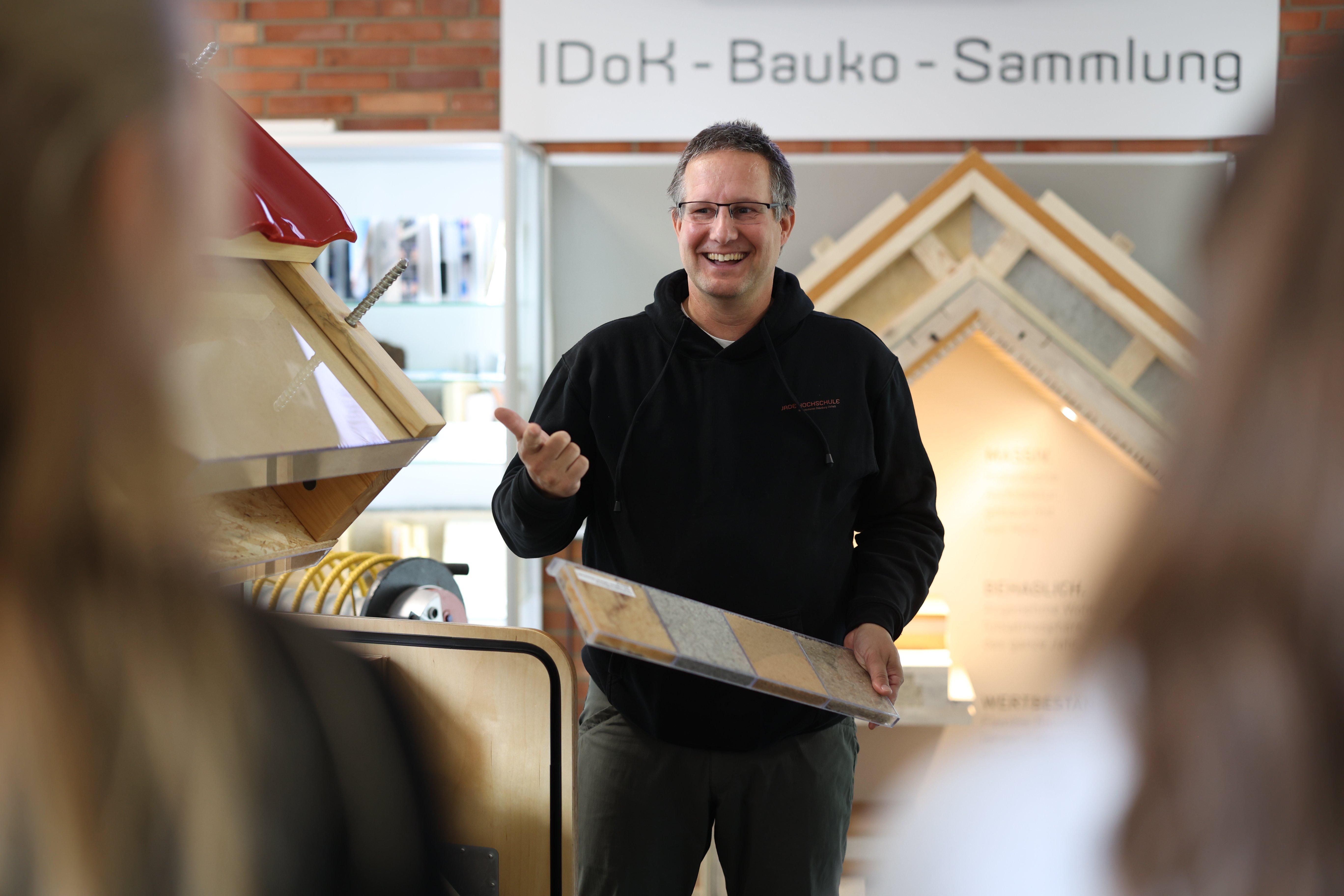 Dozent erklärt Studierenden etwas am Handmuster.