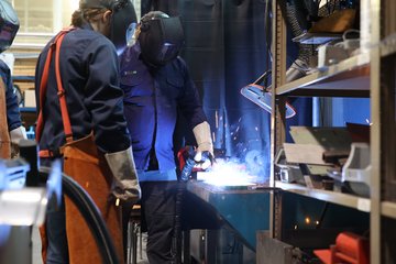 Zwei Menschen schweißen an etwas.