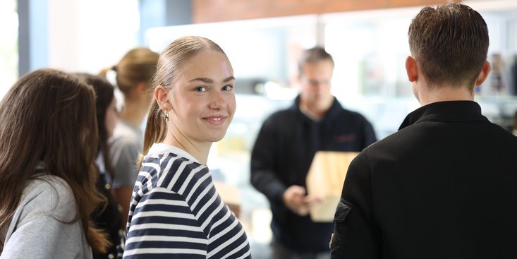 Dozent erklärt Studierenden etwas an Hand von Materialmustern.-