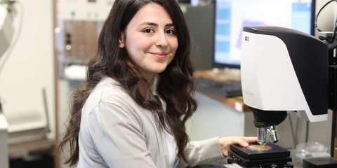 Studentin arbeitet am Mikroskop.