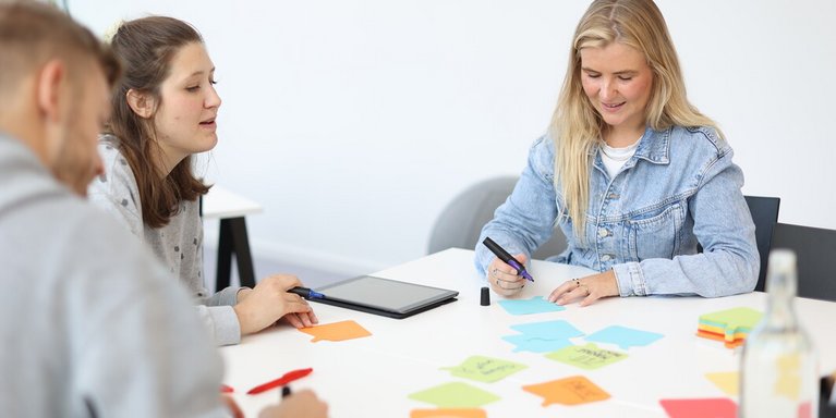Personen schreiben auf bunte Zettel