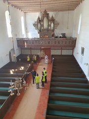 Studierende nehmen das Innere der St. Stephanuskirche in Schortens mit einem Laserscanner auf