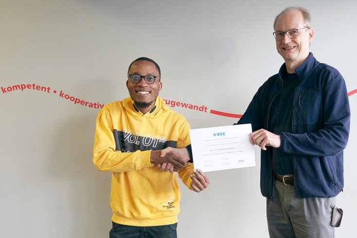 Prof. Dr. Jens Werner (re.) überreicht die Auszeichnung an Idriss Dorcel Djoumbissie Kameni (Foto: Jade HS)