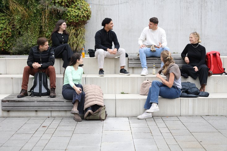 Studierende unterhalten sich auf der Tribüne des Campus Oldenburg.