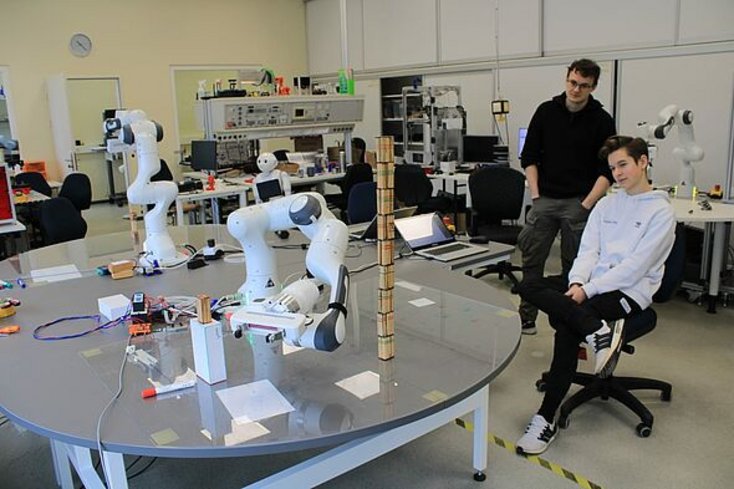 Gespannt wird dem Roboterarm beim Turmbauen zugeschaut. Im Hintergrund: der Roboter Pepper, den wir auch kennenlernen durften. (Foto: Maria-Theresia Paetz)