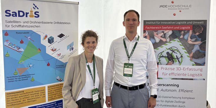 Zwei Mitarbeiter stehen auf dem Messestand.