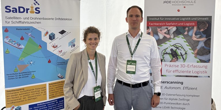 Zwei Mitarbeiter stehen auf dem Messestand.