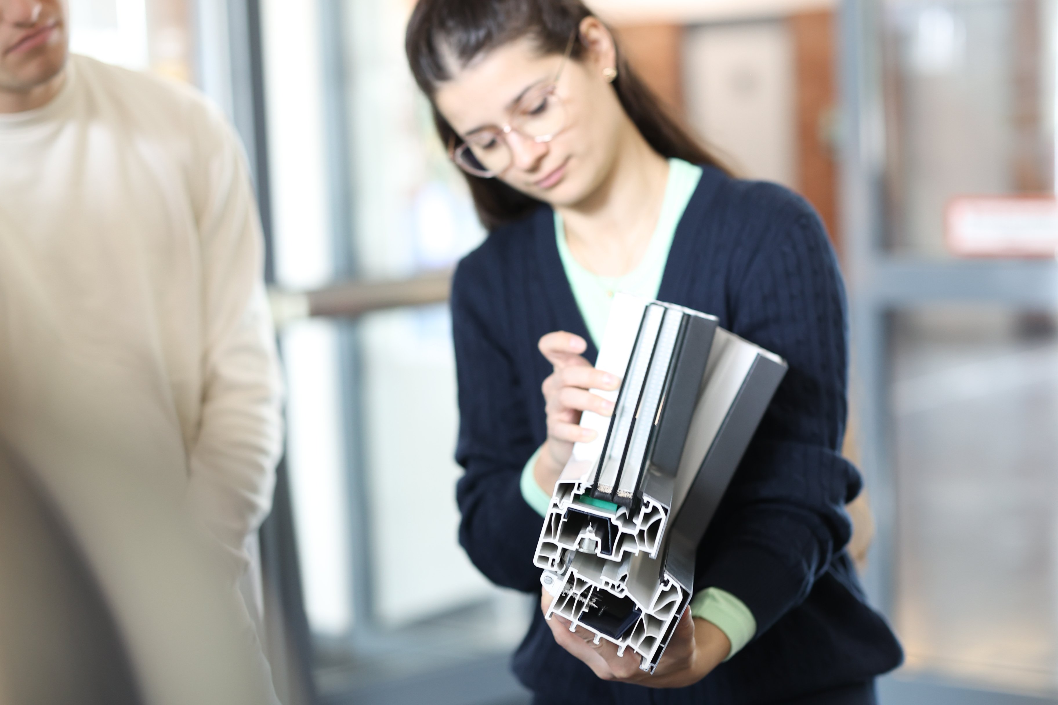 Studentin schaut sich interessiert ein Materialmuster an.