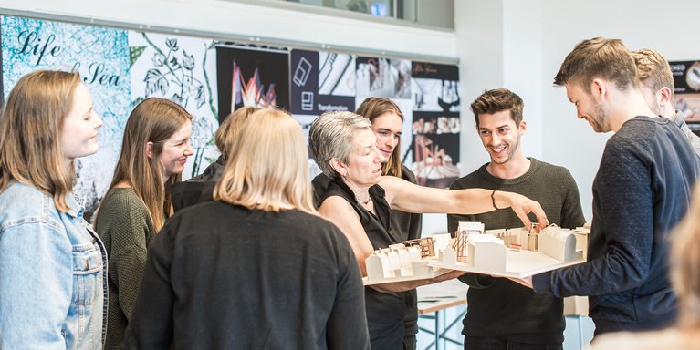 Eine Dozentin erklärt Studierenden etwas an einem Modell