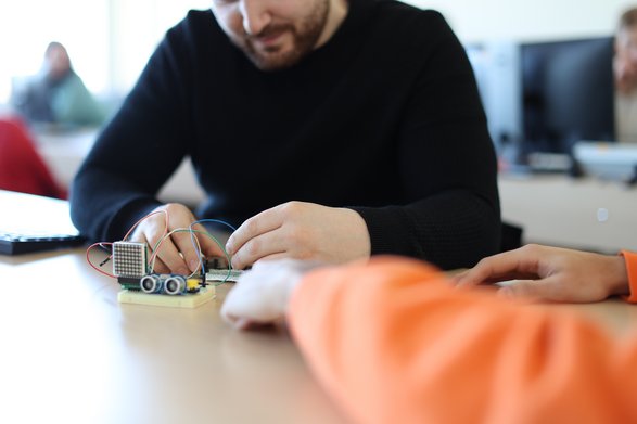 Student baut fahrenden kleinen Roboter.