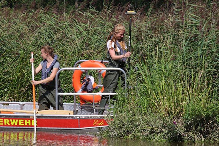 Die angehenden Geodät_innen zeigen Einsatz. Ausgestattet mit Watthosen und Rettungskragen sind sie im und auf dem Wasser unterwegs. (Foto: Piet Meyer/Jade HS)