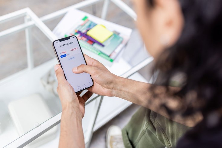 Person mit Mobiltelefon in der Hand