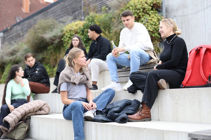 Studierende unterhalten sich auf der Tribüne des Campus Oldenburg.