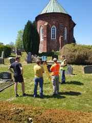 Studierenden messen den Kirchhof der St. Magnuskirche in Sande ein