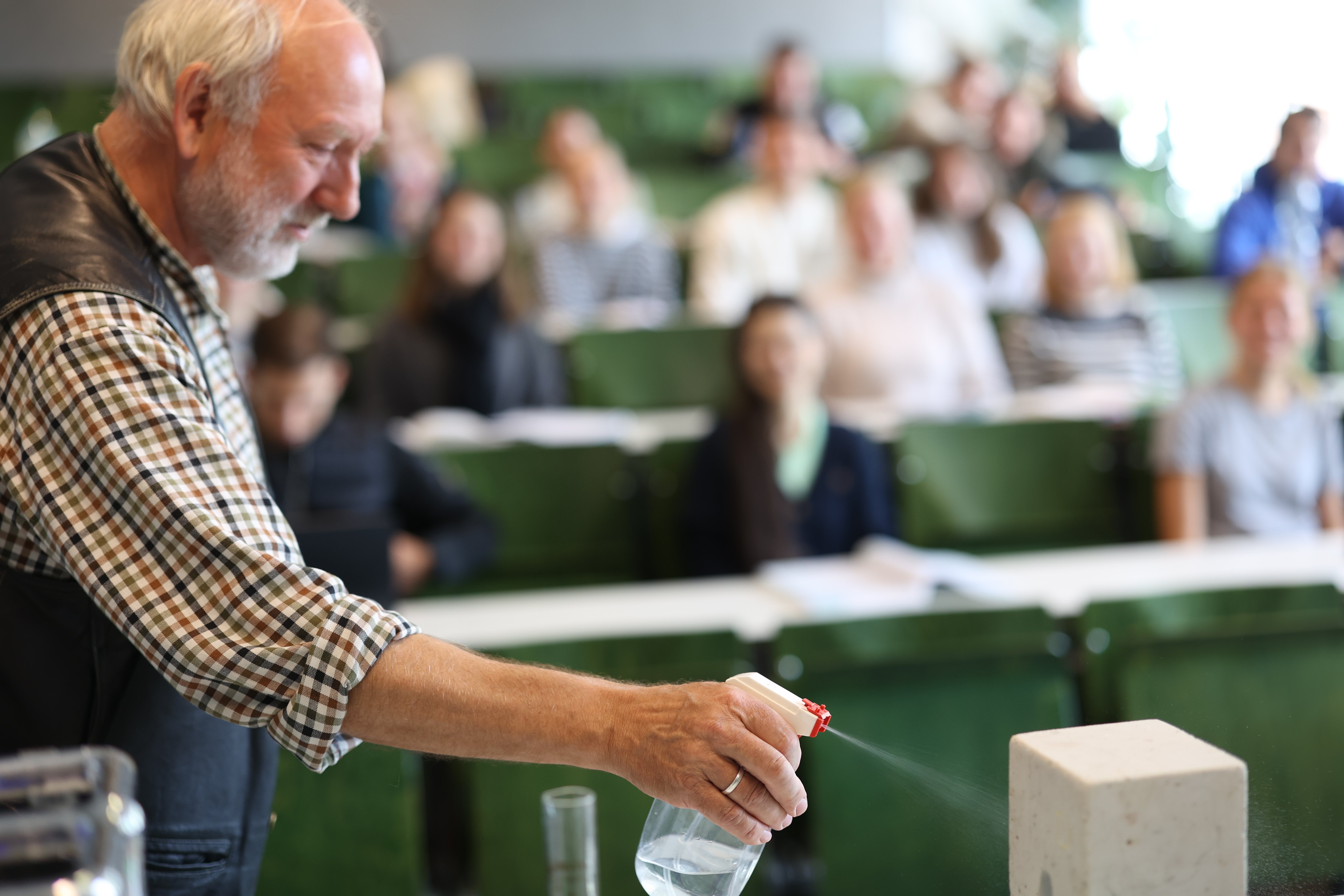 Dozent führt Experiment in Vorlesung durch.