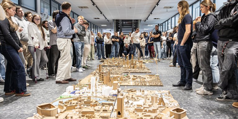 Studierende am Fachbereich Architektur stehen um ein großes Städtebaumodell 