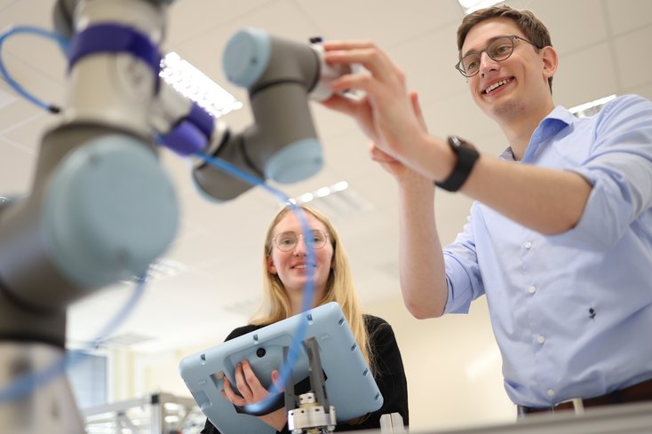 Foto: Studierende agieren mit Roboter