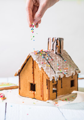 Man sprinkles Homemade gingerbread house confectionery sprinkling Man sprinkles Homemade gingerbread house confectionery sprinkling