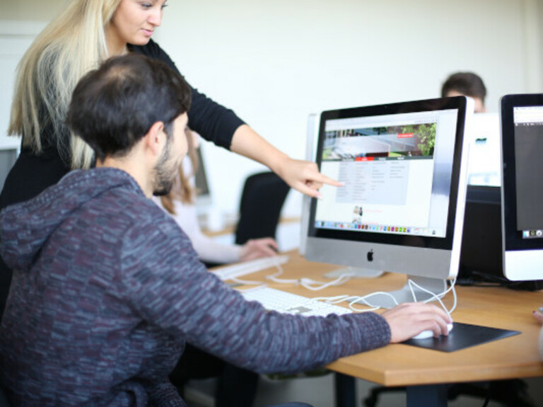 Student pointing at another student's screen