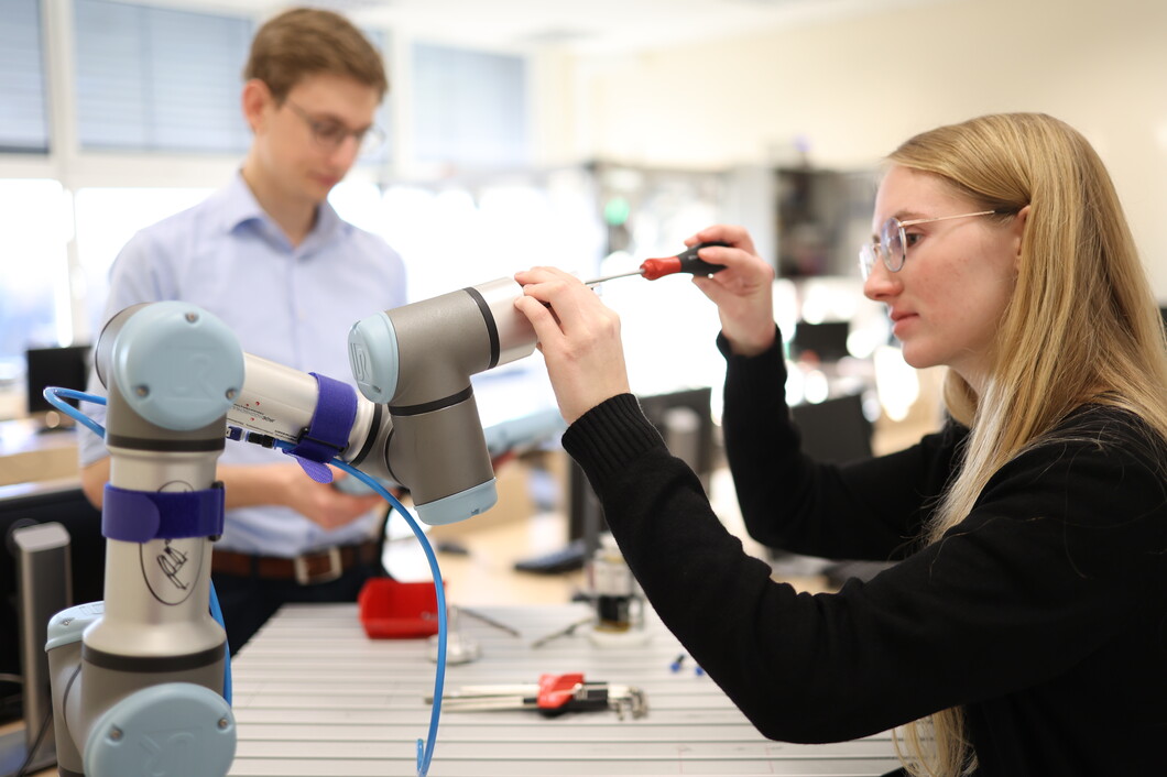 Studierende am Roboterarm
