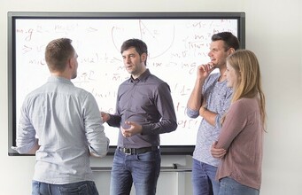 Arbeitsgruppe vor einem Digitalboard