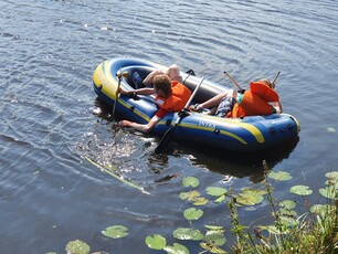 zwei Studierende Prismen haltend unterwegs im Schlauchboot